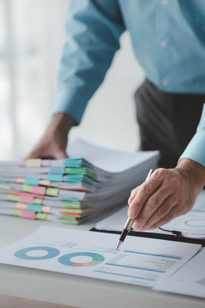 A business finance man is reviewing a company's financial documents prepared by the Finance Departme