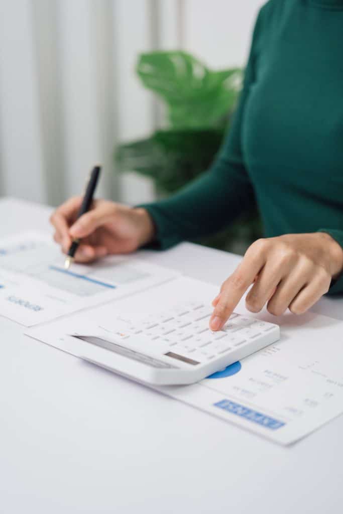 Young Asian household woman busy with bills and taxation, using calculator, make payment on tablet